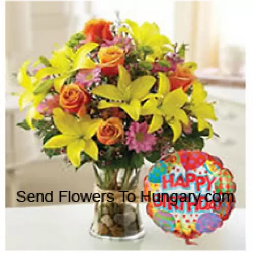 Gelbe Tulpen, orangefarbene Rosen und andere bunte Blumen, perfekt in einer Glasvase arrangiert, begleitet von einem Geburtstagsballon