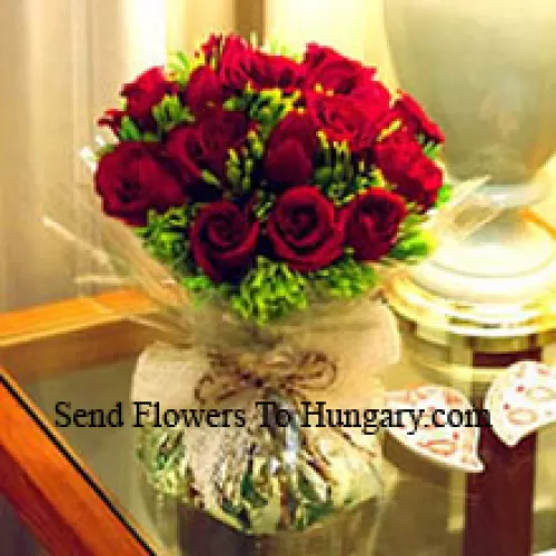 11朵红玫瑰和一些蕨类植物放在花瓶里