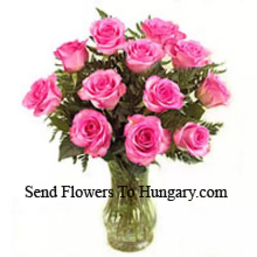 11朵粉红玫瑰和一些蕨类植物放在花瓶里