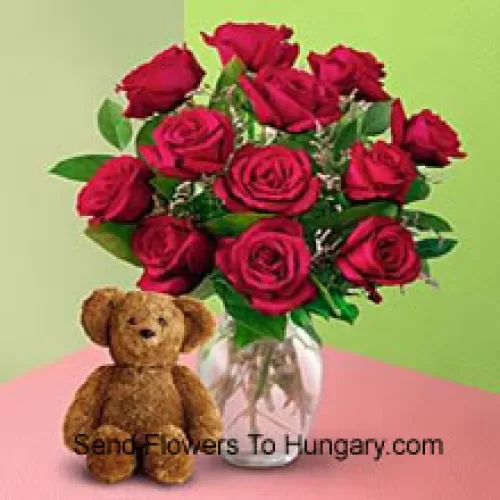 11 Trandafiri rosii cu cateva frunze de feriga intr-o vaza si un ursulet de plus maro de 8 inch